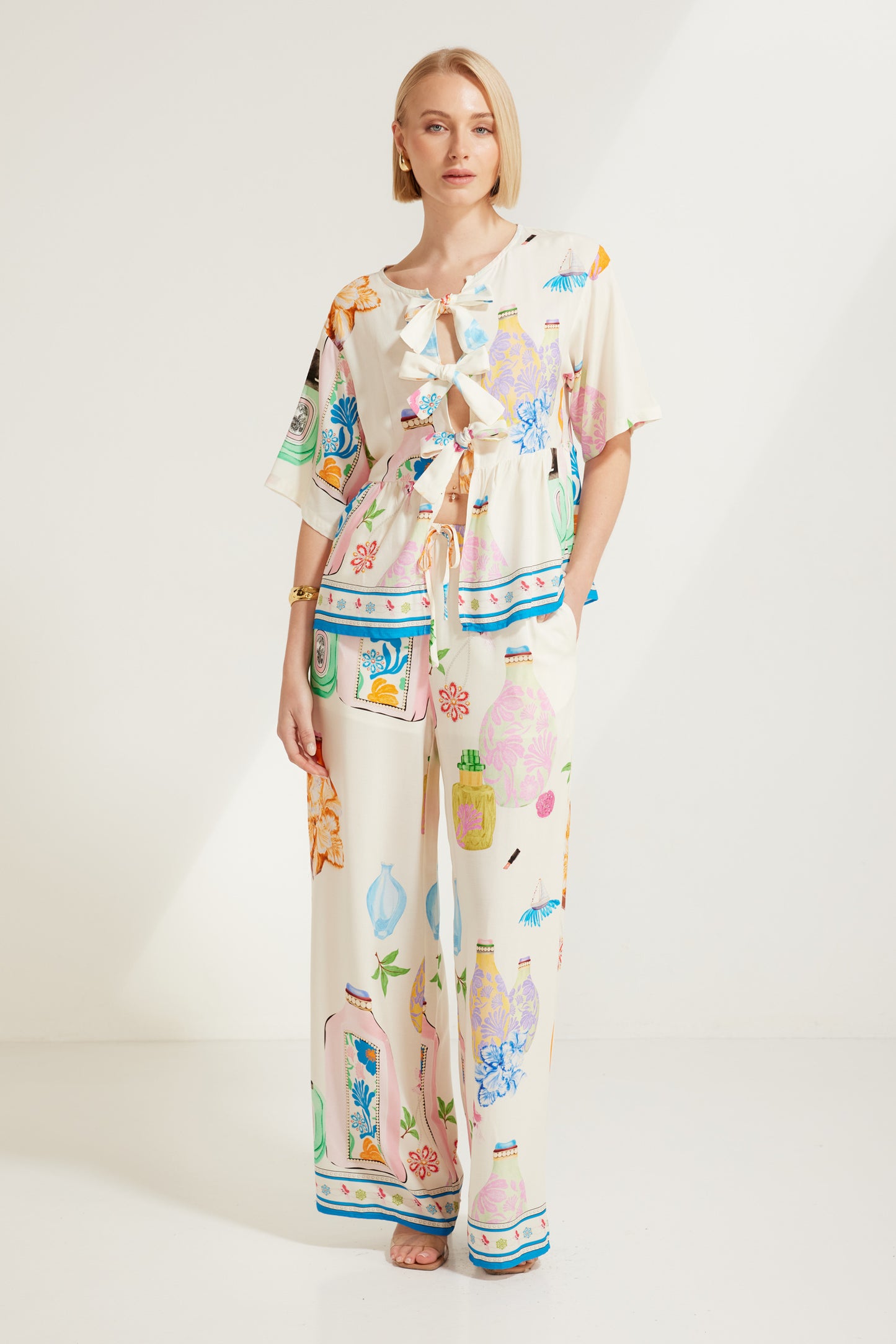 TW4320E Perfume Dreams Tie Front Top in White Print. Australian women’s WHOLESALE SHORT SLEEVE TOPS. This is a Perfume Dreams come in collection with matching sleeveless top, pant, short, jumpsuit, mini dress.